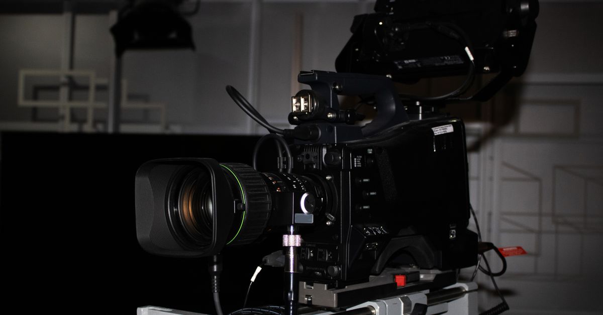 Close-up of a professional video camera rig in a studio environment, highlighting its complexity.